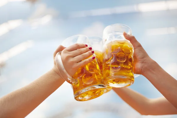 Raised beer steins toasting at Oktoberfest — Stock Photo, Image