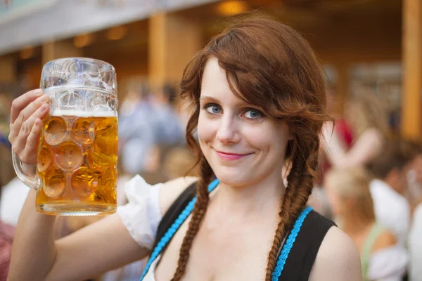 Portret van vrolijke jonge vrouw het dragen van traditionele dirndl en houden van een 1 liter bier stein op Oktoberfest — Stockfoto