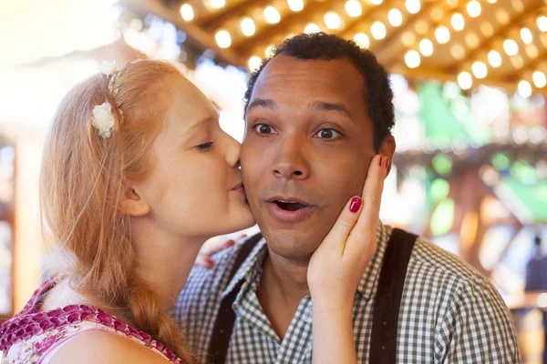 Jovem beijado na bochecha pela menina alemã no Oktoberfest — Fotografia de Stock