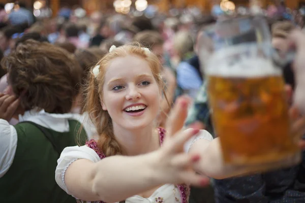 Exalterad tjej når för en mugg öl på Oktoberfest — Stockfoto