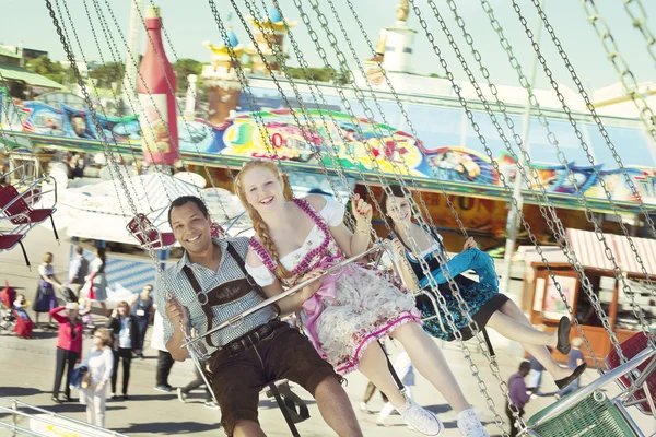 Paar amüsiert sich auf Kettenkarussell beim Oktoberfest — Stockfoto