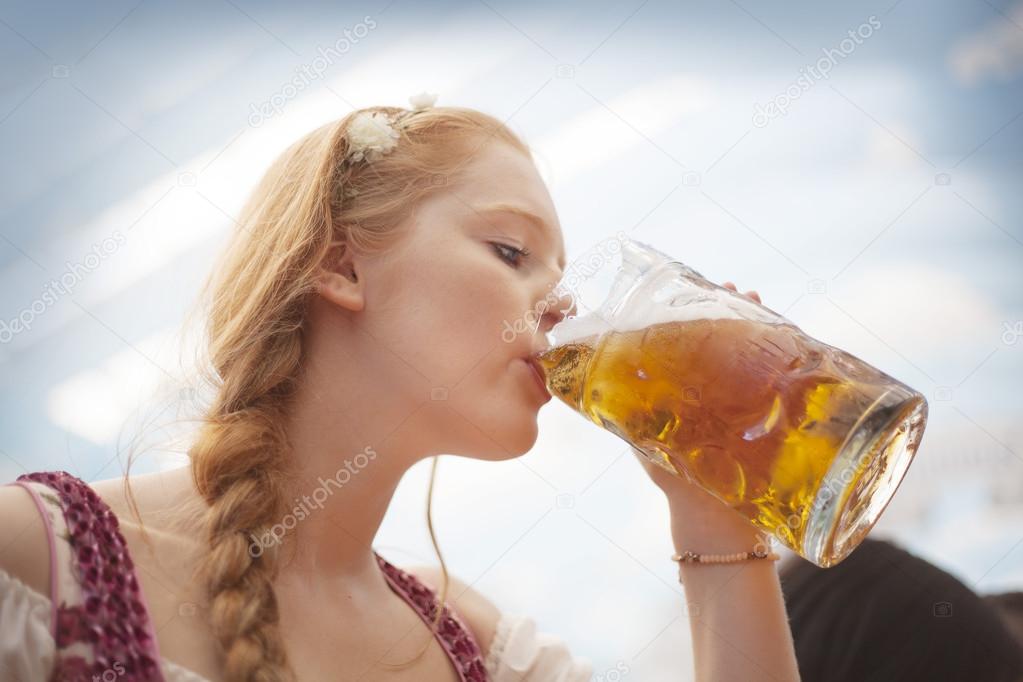 Young woman drinking beer at Oktoberfest