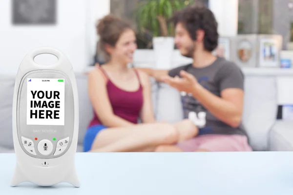 Baby monitor with copy space, and couple enjoying free time on the background — Stock Photo, Image
