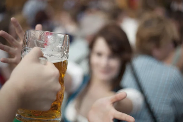 Meisje bereikt voor een mok van bier op Oktoberfest — Stockfoto
