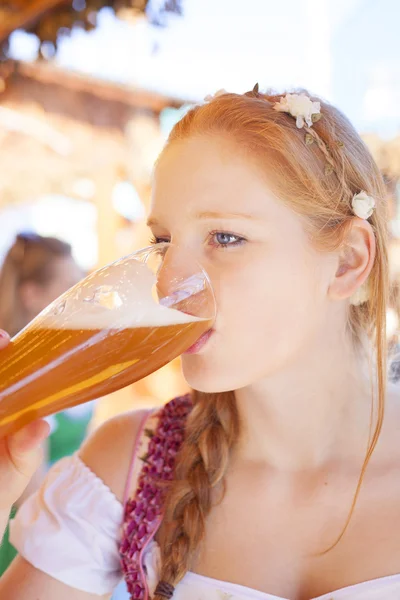 Молодая женщина пробует пиво на Октоберфесте — стоковое фото