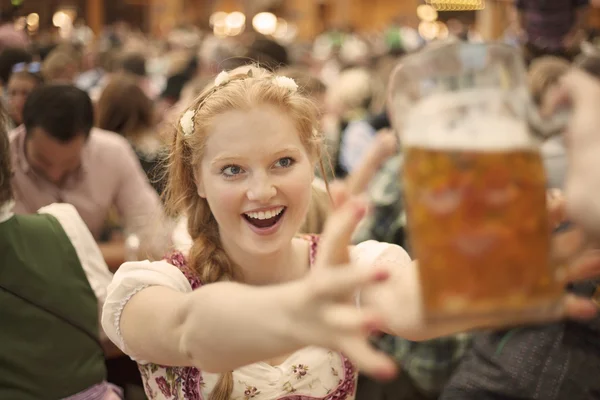 Exalterad tjej når för en mugg öl på Oktoberfest — Stockfoto