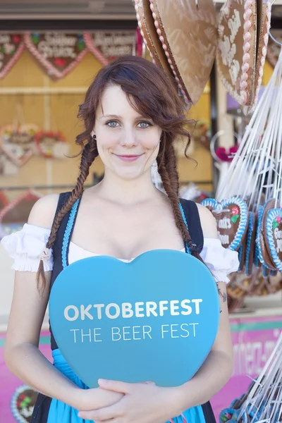 Chica alemana sosteniendo un corazón en Oktoberfest — Foto de Stock