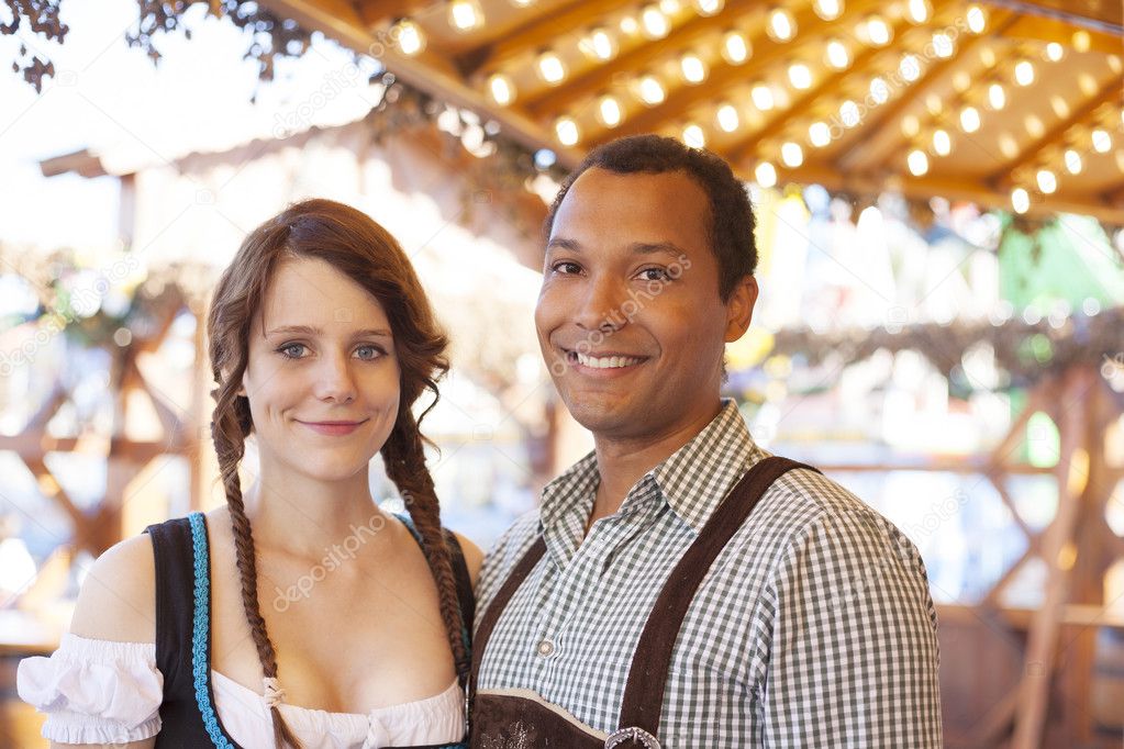 Interracial couple wearing traditional clothe, enjoying Oktoberfest in Germany 