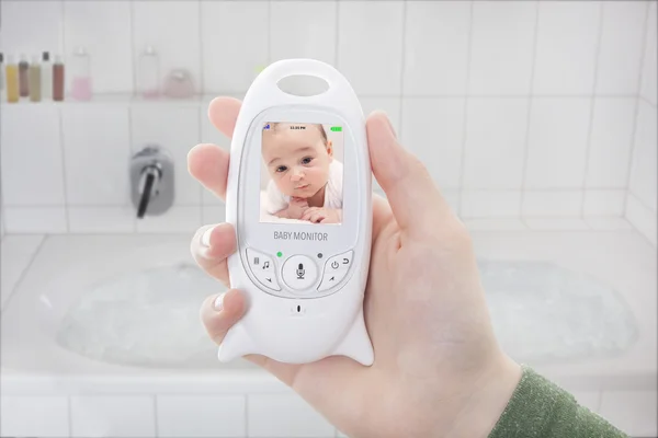 Mother checking baby through baby monitor when taking a bath — Stock fotografie