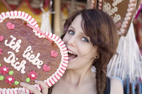 German girl with a traditional Oktoberfest's gingerbread heart — Stock Photo, Image