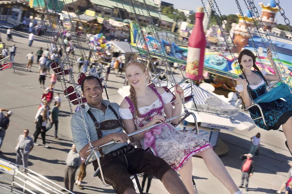 Пара веселится на карусели Кеттен-Карусселл на Октоберфесте — стоковое фото