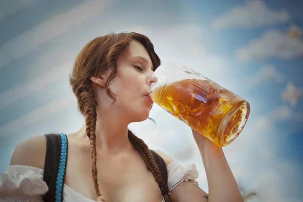 Jonge Duitse vrouw drinken van bier in een tent op Oktoberfest — Stockfoto