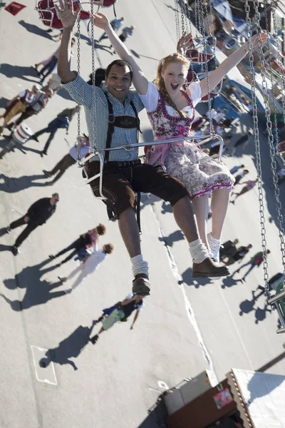 Пара веселится на карусели Кеттен-Карусселл на Октоберфесте — стоковое фото