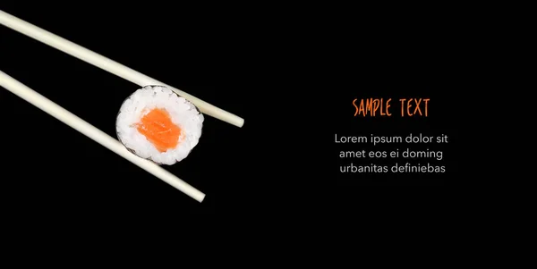 Eetstokjes holding sushi geïsoleerd op zwart - Copyspace — Stockfoto