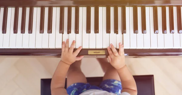 Toddler learning to play piano