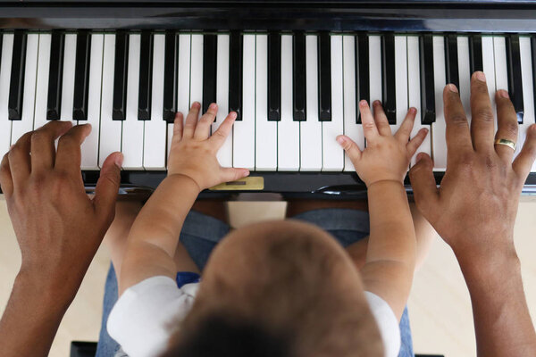 Toddler learning to play piano with father — Stock Photo, Image