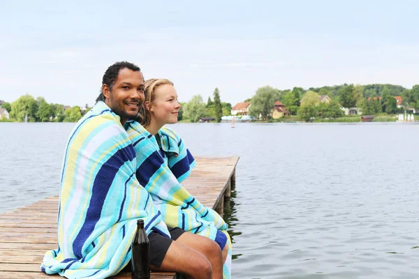 Giovane coppia in un lago avvolto in asciugamano — Foto Stock