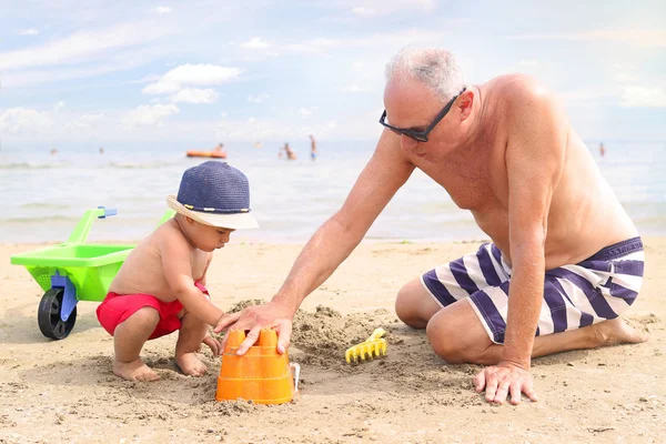 Mały chłopiec i dziadek gra na plaży — Zdjęcie stockowe