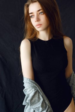 Siyah tişört ve siyah arka plan üzerine poz iç çamaşırı uzun saçlı güzel esmer