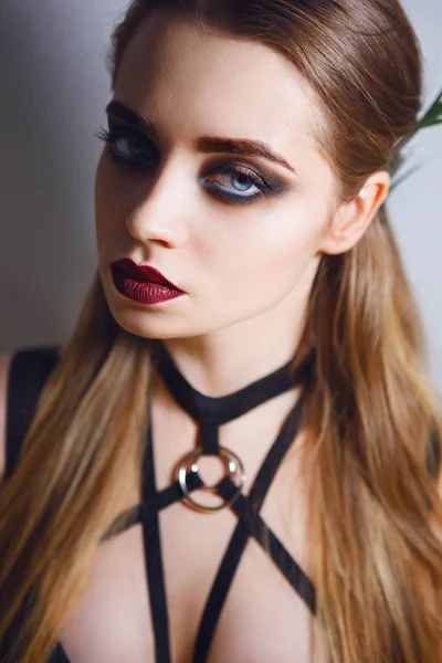 Close-up portrait of beautiful woman with bright dark make-up, red lips, long brown hair in black underwear and bandage — Stock Photo, Image