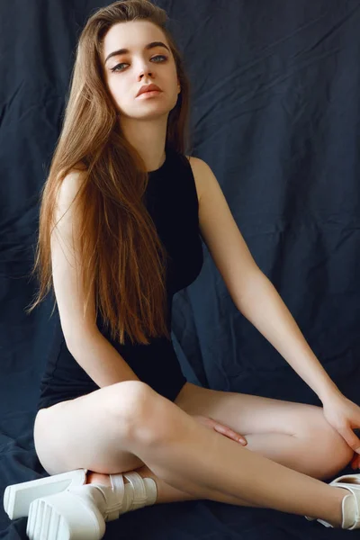 Bella bruna con i capelli lunghi in t-shirt nera e biancheria intima in posa su sfondo nero — Foto Stock