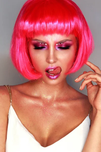 Girl in a bright pink wig with bright makeup