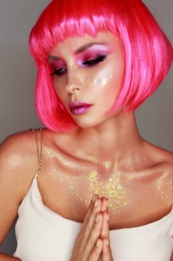 Parlak pembe peruk parlak makyaj ve Paskalya sembollerle yüzünde flash dövme ile kız