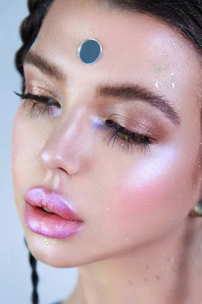 Close-up portrait of attractive model with big lips, shiny make-up and braids