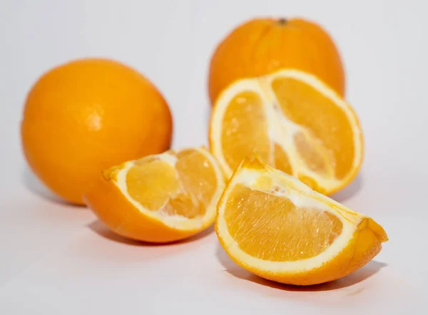 Bright slices of orange on white bacground with focus on the first one