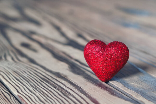 Red heart with glitter on wood