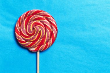 Bir çubuk üzerinde mavi bir arka plan üzerinde lolipop 