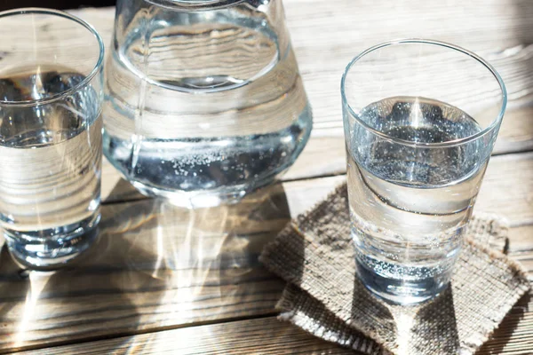 Glasögon av vatten på träbord Stockbild