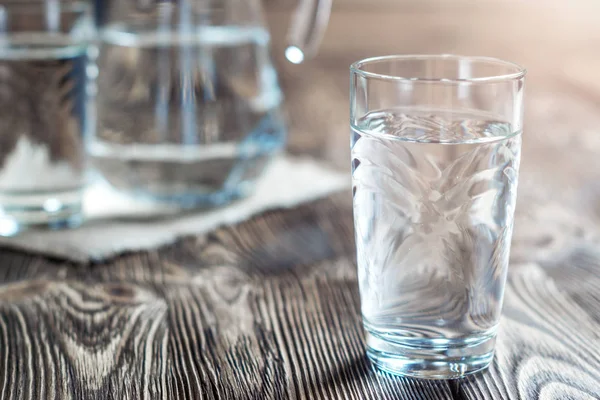 Glas med vatten på ett träbord. Stockfoto