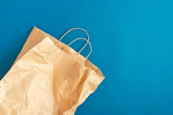 Paper bag for products on blue background. Flat lay. Zero waste.