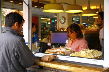 Bariloche, Arjantin - 18 Şubat 2019. Adamın biri, Bariloche 'deki ana cadde olan Calle Mitre' de bir sandviç dükkanında ödeme yapıyor.. 