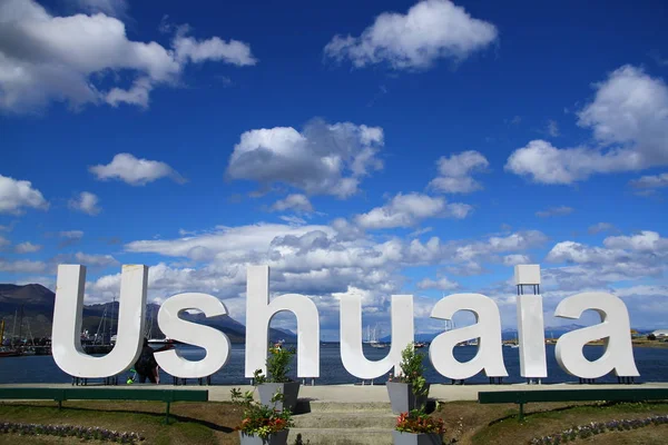 Ushuaia bakış açısına göre turistler metnin önünde fotoğraf çekiyorlar. Ushuaia, Arjantin 'in bir tatil köyüdür ve Güney Amerika' nın en güney ucu olarak kabul edilir.. 