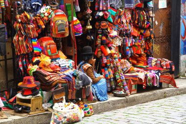 LA PAZ, BOLIVIA - 18 Mart 2019. La Paz 'daki renkli hediyelik eşya dükkanlarıyla dolu bir cadde manzarası. Şehrin en önemli turistik yerlerinden biridir..