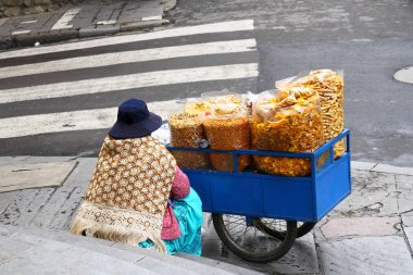 A Bolivian lady is selling snacks in La Paz in Bolivia clipart