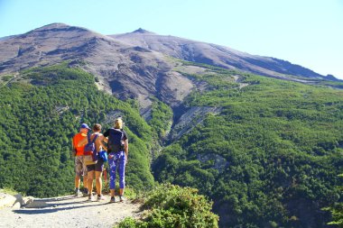 Yürüyüşçüler mola veriyor ve Şili 'deki Torres del Paine Ulusal Parkı' nın manzarasının tadını çıkarıyorlar.