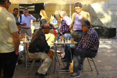 İnsanlar Şili 'nin ana meydanı olan Plaza de Armas' ta bir turnuvada satranç oynuyor.