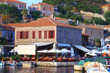 LESVOS, GREECE - 24 Ağustos 2018. Molyvos limanından deniz yemekleri ve uzo ile geleneksel Yunan mutfağının tadını çıkarabileceğiniz restoranlarla dolu bir manzara.