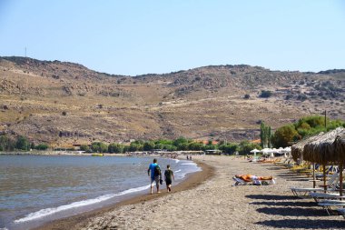 PETRA, LESVOS, GREECE - 25 Ağustos 2018. Adanın kuzeybatısındaki Petra plajlarından bir manzara. Petra 'daki bir limandan Türkiye kıyılarına feribot kalkıyor.