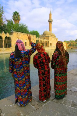 Balikligol, Sanliurfa, Türkiye - 22 Ekim 2018. Şanlıurfa 'daki kızlar renkli geleneksel elbiseleriyle kutsal Balikligol' u ziyaret ediyorlar.