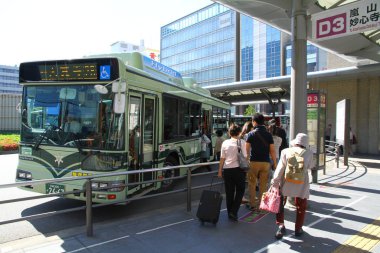 Otobüs durağındaki yolculara bakın.