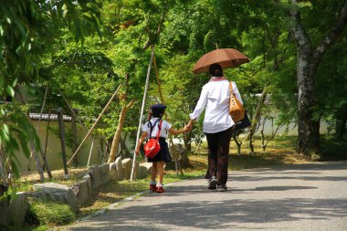 Bir anne kızını Kyoto Japonya 'da okula götürüyor.