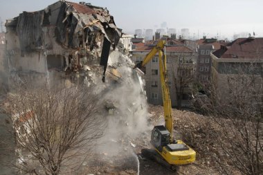 İstanbul, Türkiye - 6 Mart 2018. İstanbul 'da kentsel dönüşüm projesi için bir buldozer binaları yıkıyor.