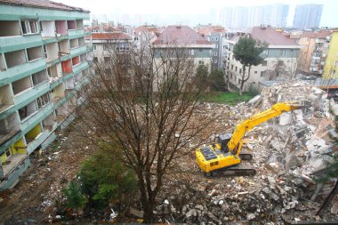 İstanbul, Türkiye - 6 Mart 2018. İstanbul 'da kentsel dönüşüm projesi için bir buldozer binaları yıkıyor.