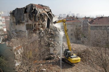 İstanbul, Türkiye - 6 Mart 2018. İstanbul 'da kentsel dönüşüm projesi için bir buldozer binaları yıkıyor.