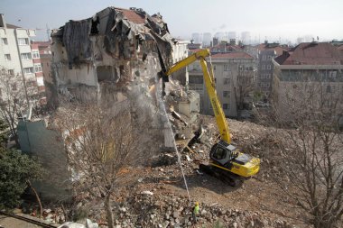 İstanbul, Türkiye - 6 Mart 2018. İstanbul 'da kentsel dönüşüm projesi için bir buldozer binaları yıkıyor.
