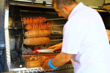 Restoranda ızgara domuz eti pişiren adamın görüntüsü.